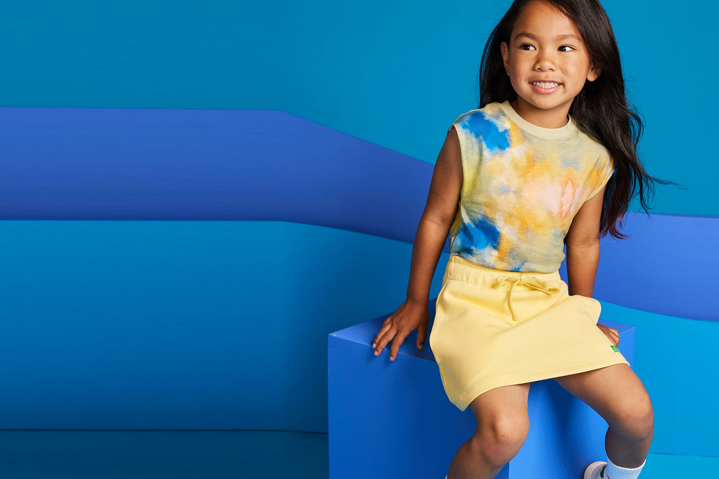 Girl wearing Cropped T-Shirt in sunset colorway and Cotton Skirt in yellow by BE.Kids
